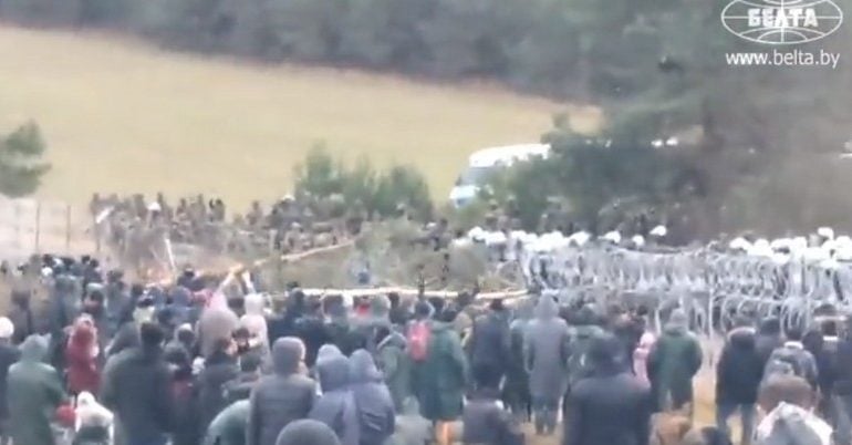 Tłum migrantów używa drzew, żeby zniszczyć ogrodzenie na polskiej granicy (WIDEO)