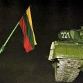 Mężczyzna trzymający flagę Litwy obok radzieckiego czołgu T-80. fot: kam.lt/images/2734/8629