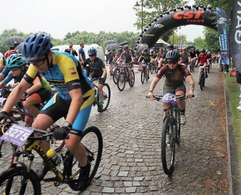 Kolorowa fotografia przedstawia fragment zawodów rowerowe wyścigi MTB (Mountain Terrain Bike) „Maratony Kresowe” oraz bieg „Kresowe Trail”