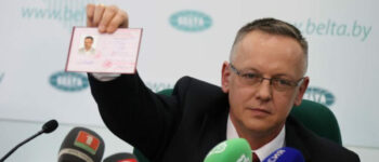Tomasz Szmydt demonstruje swój polski dokument na konferencji prasowej w Mińsku. Zdjęcie: BelTA