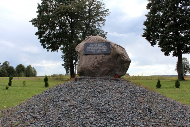 Kamień polny na sztucznym wzniesieniu przy centralnej ulicy we wsi Ludwinowo z tablicą pamiątkową w j.białoruskim, poświeconą E. Orzeszko